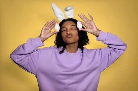 Easter studio shot with dark skinned model with easter eggs and bunny ears Stock Photos