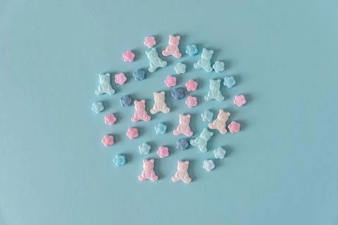 Easter Sugar Sprinkles in Shape of Teddy Bears and Flowers on Blue Background Stock Photos