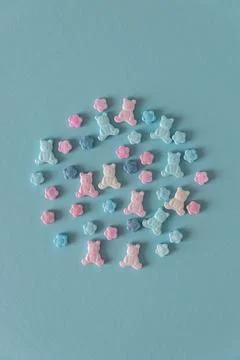 Easter Sugar Sprinkles in Shape of Teddy Bears and Flowers on Blue Background Stock Photos