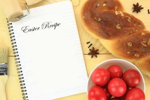 Easter sweet bread with red eggs and recipe book on the table Stock Photos