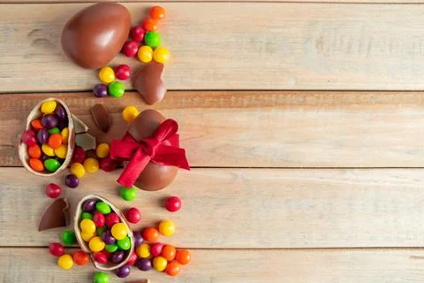 Easter sweets - chocolate eggs and sweets on a brown background. Stock Photos