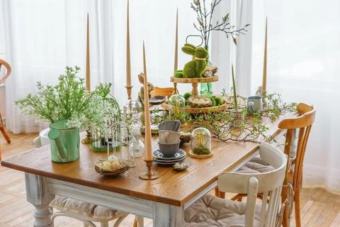 Easter table decor with candles, greenery and bunny figurines in bright spr.. Stock Photos
