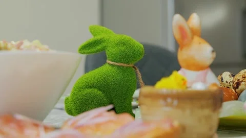 Easter table decor with green bunny figurine and festive spring holiday food Stock Footage 327771884
