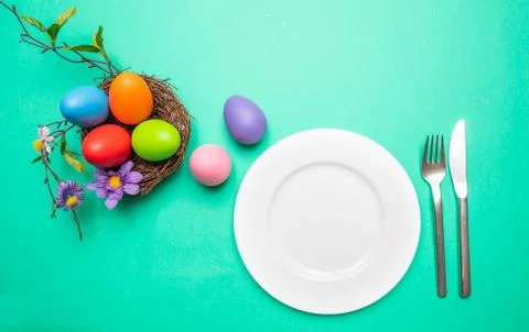Easter table, place setting. Easter eggs, pastel colors painted, empty white Stock Photos