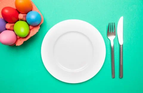 Easter table, place setting. Easter eggs, pastel colors painted, empty white Stock Photos