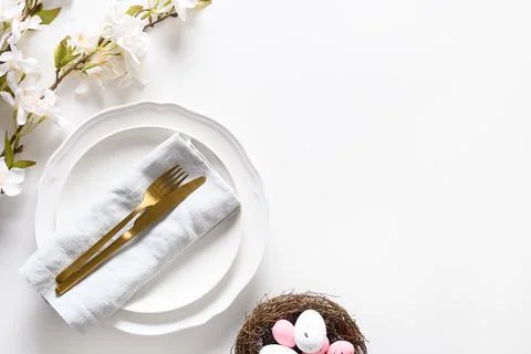 Easter table setting with blooming flowers on white table. Stock Photos