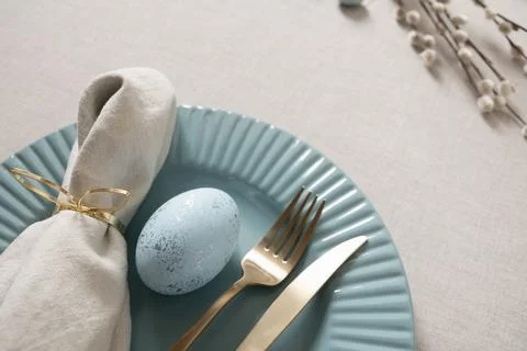 Easter table setting with blue egg and gold cutlery Stock Photos