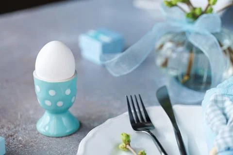 Easter Table Setting with Blue Napkin and Egg Foto stock