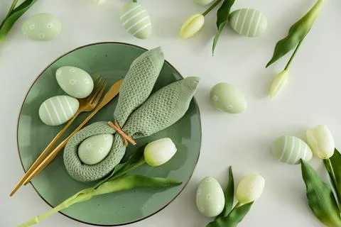 Easter Table Setting with Bunny Napkin, Decorated Eggs and Tulips. Festive .. Stock Photos
