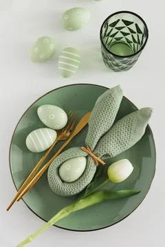 Easter Table Setting with Bunny Napkin, Decorated Eggs and Tulips. Festive .. Stock Photos