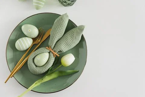 Easter Table Setting with Bunny Napkin, Decorated Eggs and Tulips. Festive .. Stock Photos