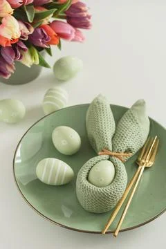 Easter Table Setting with Bunny Napkin, Decorated Eggs and Colorful Tulips... Stock Photos