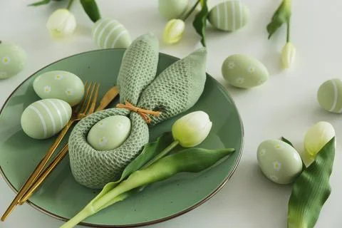 Easter Table Setting with Bunny Napkin, Decorated Eggs and Tulips. Festive .. Stock Photos