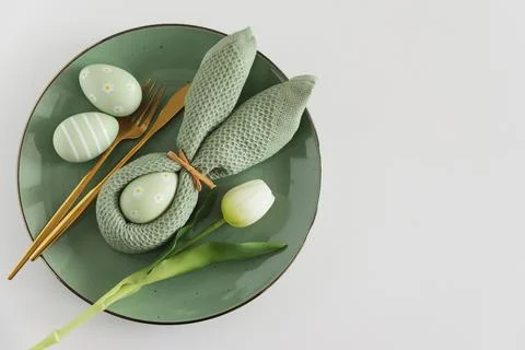 Easter Table Setting with Bunny Napkin, Decorated Eggs and Tulips. Festive .. Stock Photos