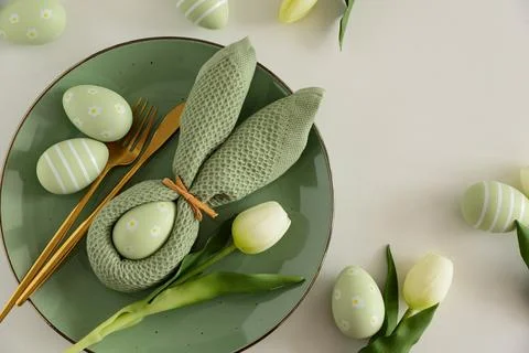 Easter Table Setting with Bunny Napkin, Decorated Eggs and Tulips. Festive .. Stock Photos