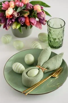Easter Table Setting with Bunny Napkin, Decorated Eggs and Colorful Tulips... Foto stock