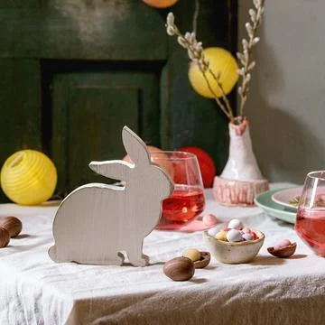Easter table setting with candies and wooden bunny Foto stock