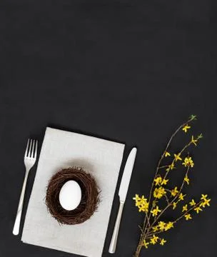 Easter table setting with a chicken egg in a nest on a linen napkin  Stock Photos