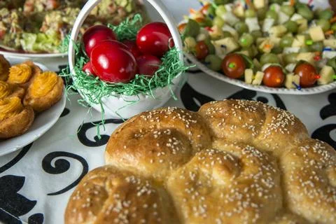 Easter table setting with colored red eggs, bread, green branches decorated.. Stock Photos
