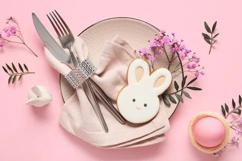 Easter table setting with cookie in shape of bunny, egg, olive branches and g Stock Photos