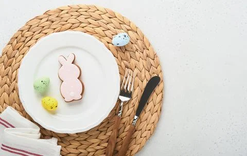 Easter table setting. Easter dinner with white bunny, fresh spring flowers an Stock Photos