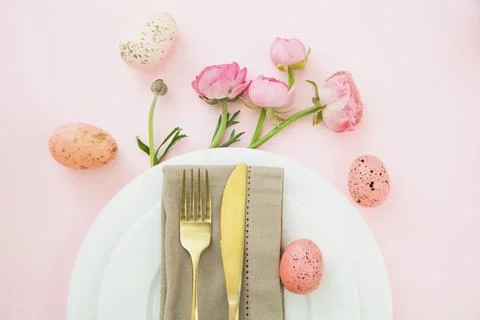 Easter table setting, Easter eggs and flowers decoration, napkin and golden c Foto stock