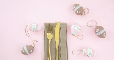 Easter table setting, Easter eggs decoration, napkin and golden cutlery on pa Stock Photos