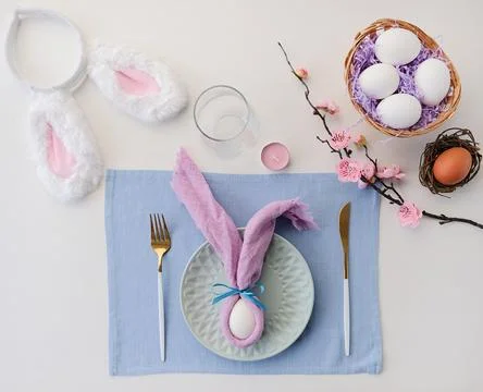 Easter table setting, egg with bunny ears on plate on the table decorated for Stock Photos