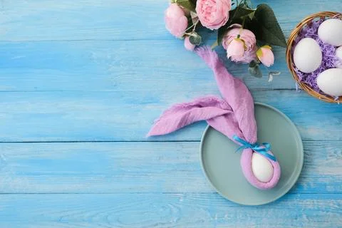 Easter table setting, egg with bunny ears on plate on table decorated for E.. Stock Photos