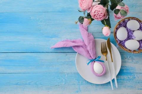 Easter table setting, egg with bunny ears on plate on table decorated for E.. Stock Photos