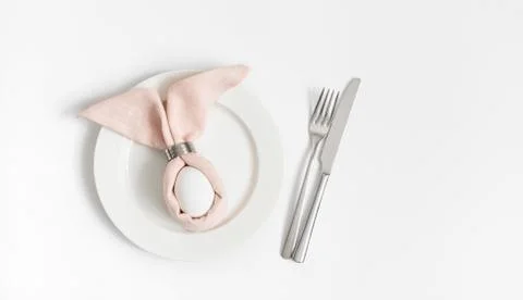 Easter table setting with egg in pink Easter bunny napkin  Stock Photos