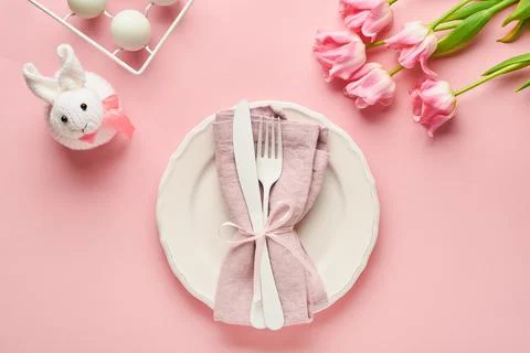 Easter table setting with floral decor on pink table. Elegance dinner. Mock u Stock Photos