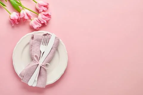 Easter table setting with floral decor on pink table. Elegance dinner. Mock u Stock Photos