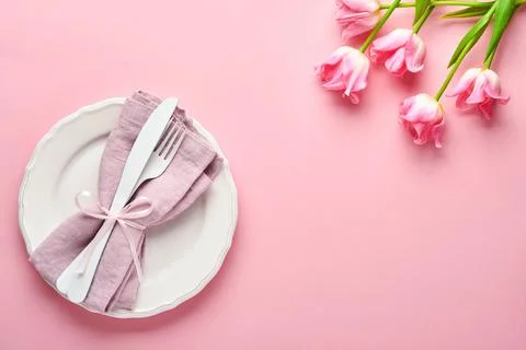 Easter table setting with floral decor on pink table. Elegance dinner. Mock u Stock Photos