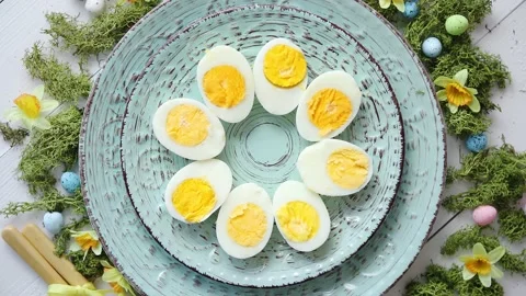 Easter table setting with flowers and eggs. Decorative plates with boiled eggs 動画素材 151118717