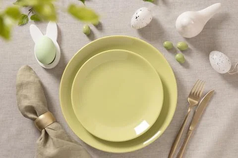 Easter table setting with green plates and spring decor Stock Photos