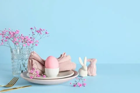 Easter table setting with painted egg, gypsophila flowers and ceramic rabbits Stock-Fotos