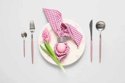 Easter table setting with painted egg, hyacinth flower and napkin on grey bac Stock Photos