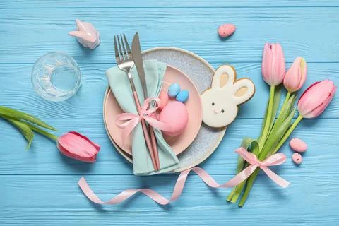 Easter table setting with painted eggs, tulip flowers, cookie and ceramic rab Stock Photos