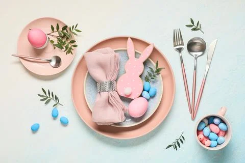 Easter table setting with painted eggs, olive branches and wooden rabbit on l Stock Photos