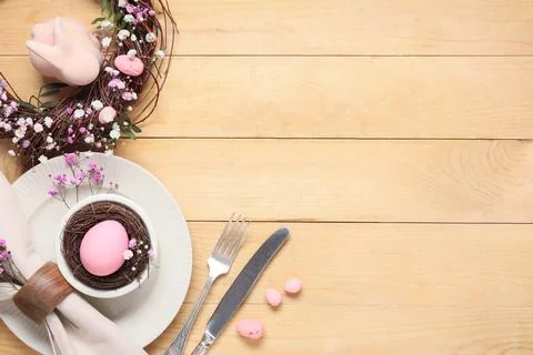 Easter table setting with painted eggs, wreath, olive branches, gypsophila fl Stock Photos