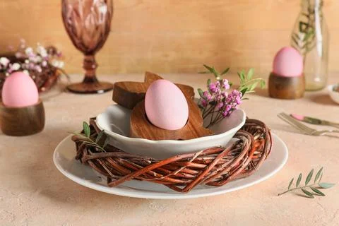 Easter table setting with painted eggs, gypsophila flowers, olive branches an Stock Photos