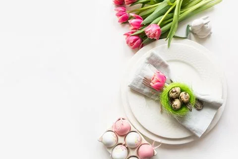 Easter table setting with pink tulip on white. Spring romantic dinner. Stock Photos