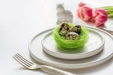 Easter table setting with pink tulip on white. Spring romantic dinner. Stock Photos