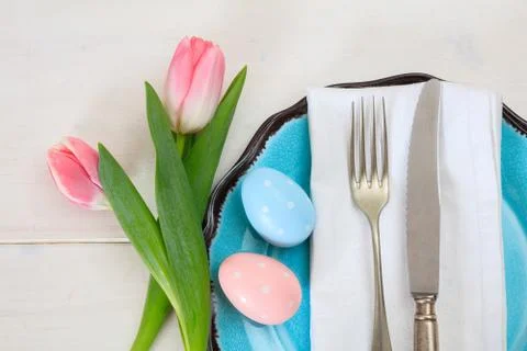 Easter table setting with pink tulips on white wooden background. Top view Stock Photos