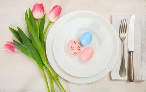 Easter table setting with pink tulips on white wooden background. Top view Stock Photos