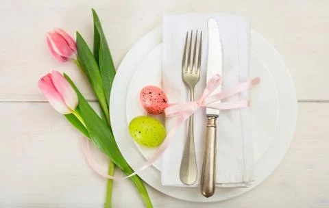 Easter table setting with pink tulips on white wooden background. Top view Stock Photos