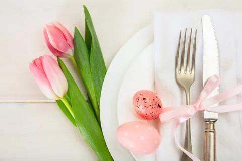 Easter table setting with pink tulips on white wooden background. Top view 写真素材