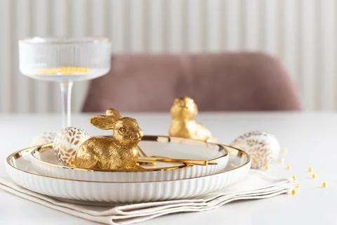 Easter Table Setting with Plates and Golden Decor on White Table 스톡 사진