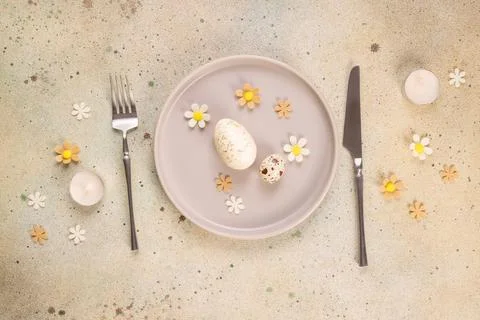 Easter table setting with speckled eggs and spring flowers Stock Photos